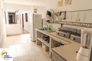 uma cozinha com electrodomésticos brancos e piso em azulejo em KOMODO ALOJAMIENTO- hostal autoservicio - ubicado muy cerca al centro histórico -Habitaciones con baño privado, wifi , cama 2x2 em Popayán