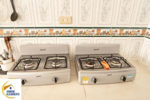 two stove tops in a kitchen with white cabinets at KOMODO Alojamiento - hostal autoservicio, ubicado cerca al centro - baño privado, wifi , cama 2x2, agua caliente y cocina comunitaria in Popayan