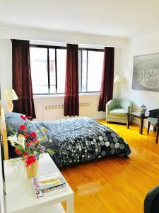 - une chambre avec un lit et une table fleurie dans l'établissement Stylish Montreal Apartment: Comfortable Stay in the Golden Square Mile, à Montréal