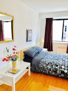 a bedroom with a bed and a table with flowers on it at Stylish Montreal Apartment: Comfortable Stay in the Golden Square Mile in Montreal