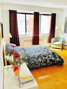 a bedroom with a bed and a table with flowers at Stylish Montreal Apartment: Comfortable Stay in the Golden Square Mile in Montreal