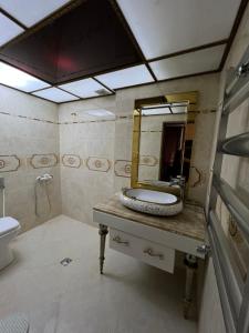 y baño con lavabo y espejo. en Genclik, en Baku