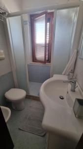 a bathroom with a sink and a toilet and a shower at Casa di Catalina in Favignana