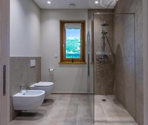 a bathroom with a toilet and a glass shower at Casa dei Giardini B&B in Mondovì