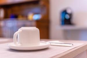una taza de café blanca sobre una mesa en Casa dei Giardini B&B en Mondovì