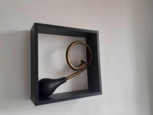a magnifying glass in a black frame on a wall at Alloggio Torino InQuadro in Turin