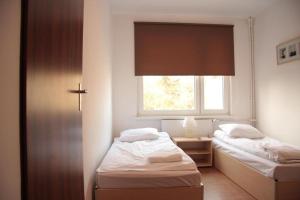 twee bedden in een kleine kamer met een raam bij HOSTEL 24 in Bydgoszcz