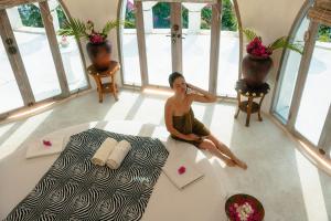 a woman sitting on the floor in a room at Villa Wisdome - 2 bedrooms in Teluknarat