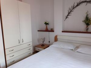 a bedroom with a white bed and a white cabinet at Residence La Playa in Marina di Camerota