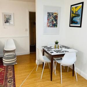 a dining room with a table and white chairs at Artist's retreat near the heart of the city in Sacramento