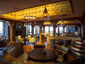 波特拉什的住宿－Golflinks Hotel，一间带桌椅的餐厅和一间酒吧