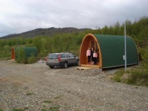 a couple of people standing in a small tent at Vinland Camping Pods in Egilsstaðir