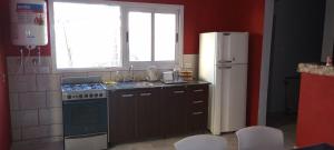 a small kitchen with a refrigerator and a sink at Casa Chuchi in Reconquista