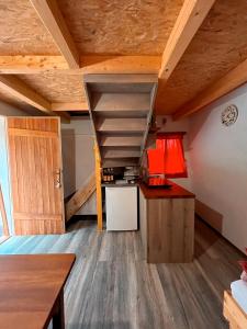 a kitchen with wooden ceilings and a staircase in a room at Koča Janka in Metke in Velika Loka