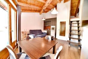 ein Wohnzimmer mit einem Holztisch und Stühlen in der Unterkunft Encantador ático estudio delante GrandValira HUT 5163 in El Tarter