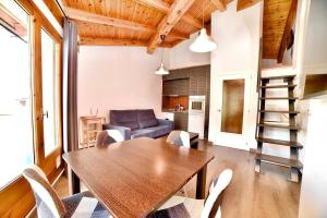 エル・タルテルにあるEncantador ático estudio delante GrandValira Tarter 4A HUT 5163の木製のテーブルと椅子のあるリビングルーム