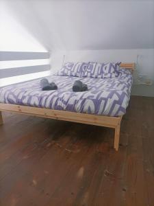 1 cama con edredón morado en el suelo de madera en Villa Chinija, en La Vegueta