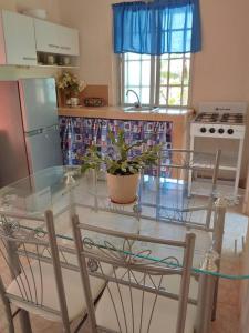 cocina con mesa de cristal y 2 sillas en Cozy 1 br 1 bath apartment with free parking, en Penonomé