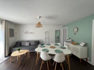 een woonkamer met een tafel en stoelen en een bank bij Villa Moana Soustons plage / Vieux-Boucau in Soustons