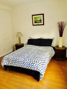 um quarto com uma cama preta e branca com duas mesas em Stylish Montreal Apartment: Comfortable Stay in the Golden Square Mile em Montreal