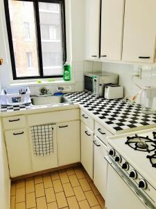 uma cozinha branca com um lavatório e um fogão em Stylish Montreal Apartment: Comfortable Stay in the Golden Square Mile em Montreal