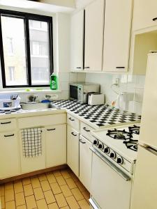 uma cozinha com armários brancos e um forno com placa de fogão em Stylish Montreal Apartment: Comfortable Stay in the Golden Square Mile em Montreal