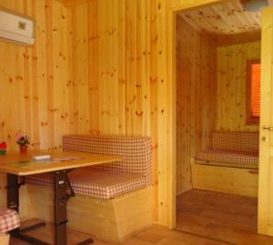 a room with a table and benches in a cabin at Campeggio Punta di Crabbia in Pettenasco