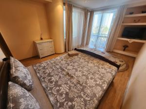 ein großes Bett in einem Zimmer mit einem großen Fenster in der Unterkunft Modern Vision 1-room Apartament in Hipermarket Nr-1 in Chişinău