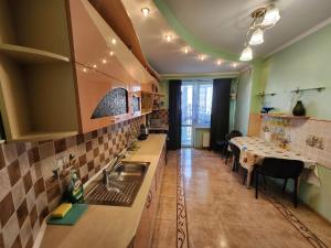 eine Küche mit einem Waschbecken und einem Tisch darin in der Unterkunft Modern Vision 1-room Apartament in Hipermarket Nr-1 in Chişinău