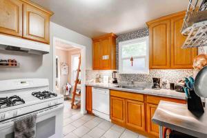 a kitchen with wooden cabinets and a white stove top oven at Smart Eclectic ART HOUSE near the beat in Sacramento