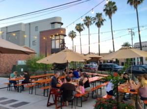 a group of people sitting at tables with umbrellas at Smart Eclectic ART HOUSE near the beat in Sacramento