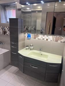 La salle de bains est pourvue d'un lavabo et d'un miroir. dans l'établissement Star Street Home, à Mosonmagyaróvár