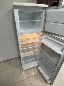 an empty refrigerator with its door open in a kitchen at Star Street Home in Mosonmagyaróvár