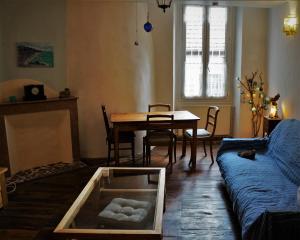 - un salon avec une table et un canapé bleu dans l'établissement La lanterne, à Gap