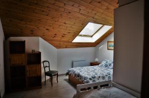 een slaapkamer met een bed en een plafond met een dakraam bij La lanterne in Gap