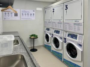 uma lavandaria com duas máquinas de lavar roupa e um lavatório em Vista Alta-23ºandar/Academia/Insper e Hosp.São Luiz 650mts/Pq.Ibirapuera 1Km/ WiFi 257Mbps em São Paulo