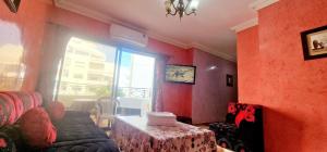 un soggiorno con divano, tavolo e finestra di Complejo al andalous Apartamento a Tangeri