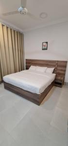 a bedroom with a large bed with a wooden headboard at ALOEVERA VILLAS & CAFA in Sayq