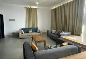 a living room with two couches and a table at ALOEVERA VILLAS & CAFA in Sayq