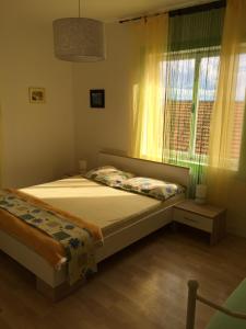 a bedroom with a bed and a window at Apartments Stakic in Krvavica