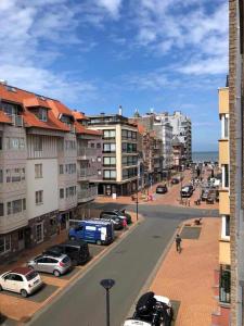 a city street with cars parked in a parking lot at La perle du Nord in Middelkerke