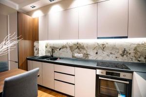 uma cozinha com armários brancos e uma bancada em Luxury Apartment at Condor Center em Tirana