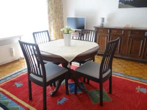 a dining room table with four chairs and a television at Apartment Birkenstrasse 52 Wohnung 2 by Interhome in Engelberg