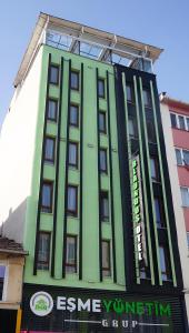 a green building with a sign on the side of it at Blaundus Otel in Uşak