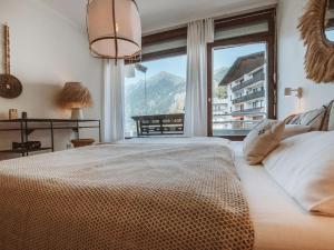 sypialnia z dużym łóżkiem i dużym oknem w obiekcie Apartment Tauernspirit by Interhome w mieście Bad Gastein
