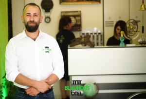 a man standing in a kitchen with his arms crossed at Blaundus Otel in Uşak