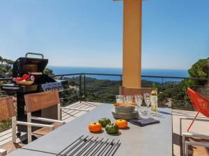 Una mesa con calabazas y copas de vino en un balcón. en Holiday Home Floradise by Interhome, en Lloret de Mar