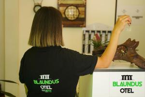 a woman in a black shirt is holding a fake tree branch at Blaundus Otel in Uşak