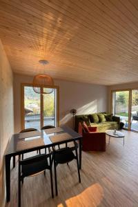 ein Wohnzimmer mit einem Tisch, Stühlen und einem Sofa in der Unterkunft Apartment Gletscherhorn Sockelgeschoss Südwest by Interhome in Zweisimmen