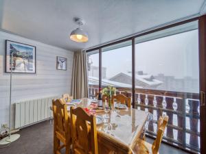 une salle à manger avec une table et une grande fenêtre dans l'établissement Apartment Le Sérac-10 by Interhome, à Val Thorens